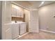 Bright laundry room with washer, dryer, upper cabinets, and door at 31718 Blue Passing Loop, Wesley Chapel, FL 33545