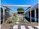 A shot of the backyard showcasing the garden pergola and home's blue exterior at 3309 Bayport Dr, Holiday, FL 34691