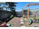 Fenced backyard with pergola, garden, small pavers and a shady tree at 3309 Bayport Dr, Holiday, FL 34691