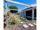 A view of the pergola over the garden area, featuring a blue home exterior at 3309 Bayport Dr, Holiday, FL 34691