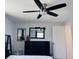 Bedroom with white bedding and a black dresser with a decorative mirror at 3309 Bayport Dr, Holiday, FL 34691