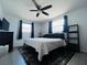 Bedroom with black ceiling fan, gray tile floors, and a black and white area rug at 3309 Bayport Dr, Holiday, FL 34691