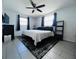 Bedroom with black ceiling fan, gray tile floors, and a black and white area rug at 3309 Bayport Dr, Holiday, FL 34691