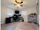 Bedroom featuring tile floors, ceiling fan, desk with monitors, and a collection of shoes in display cases at 3309 Bayport Dr, Holiday, FL 34691