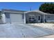 Single story home featuring a garage and charming blue paint. A concrete driveway leads to the garage at 3309 Bayport Dr, Holiday, FL 34691