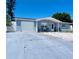 Single story home featuring a garage and charming blue paint. A concrete driveway leads to the garage at 3309 Bayport Dr, Holiday, FL 34691