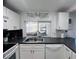 Bright kitchen features white cabinets, subway tile backsplash, breakfast bar, and tile flooring at 3309 Bayport Dr, Holiday, FL 34691
