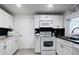 Bright kitchen features white cabinets, subway tile backsplash, breakfast bar, and tile flooring at 3309 Bayport Dr, Holiday, FL 34691
