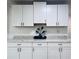 Bright kitchen featuring white cabinets, modern hardware, and speckled granite countertops at 3309 Bayport Dr, Holiday, FL 34691