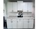 Bright kitchen featuring white cabinets, modern hardware, and speckled granite countertops at 3309 Bayport Dr, Holiday, FL 34691