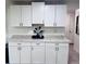 Bright kitchen featuring white cabinets, modern hardware, and speckled granite countertops at 3309 Bayport Dr, Holiday, FL 34691
