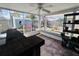 Enclosed porch featuring ceiling fan, exterior backyard view, bar and storage shelves at 3309 Bayport Dr, Holiday, FL 34691