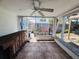 Enclosed porch featuring a ceiling fan, tile floor, outdoor bar and view of shed in backyard at 3309 Bayport Dr, Holiday, FL 34691