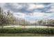 Community basketball court and volleyball court with mesh fencing and surrounding greenery at 3515 Albritton St, New Port Richey, FL 34655