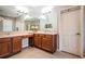 Bathroom featuring double sinks, large mirrors, and a neutral tile floor at 3515 Albritton St, New Port Richey, FL 34655