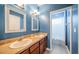 Stylish blue bathroom with double sinks, large mirrors, and a separate shower area at 3515 Albritton St, New Port Richey, FL 34655