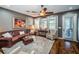 Comfortable living room with brown leather sofa, a ceiling fan, and hardwood flooring at 3515 Albritton St, New Port Richey, FL 34655