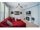 Bright living room features plush red sofa, fireplace, ceiling fan, and neutral paint at 3515 Albritton St, New Port Richey, FL 34655