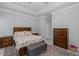 Traditional bedroom featuring an upholstered bench, a wood frame bed, and decorative floral bedding at 4082 Watson Dr, New Port Richey, FL 34655