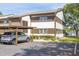 Two-story condo with covered parking, showcasing its architecture and manicured landscaping at 4140 Passport Ln # 204, New Port Richey, FL 34653