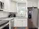 Updated kitchen with stainless appliances, white cabinets, and granite countertops at 4140 Passport Ln # 204, New Port Richey, FL 34653