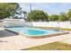 Community pool with a brick border and a white fence at 4140 Passport Ln # 204, New Port Richey, FL 34653