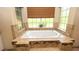 Large bathtub with tile surround, with jacuzzi jets and a large window with a blind at 4475 Rachel Blvd, Spring Hill, FL 34607