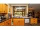 Well-lit kitchen featuring granite countertops, wooden cabinets, and a view of the backyard through a large window at 4475 Rachel Blvd, Spring Hill, FL 34607