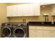 Spacious laundry room equipped with modern appliances, sink, countertops, and ample cabinet storage at 4475 Rachel Blvd, Spring Hill, FL 34607