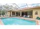 Backyard pool features a screened enclosure and outdoor seating area at 4475 Rachel Blvd, Spring Hill, FL 34607