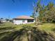 Well-maintained backyard with a screened-in porch, lush green lawn, and secure chain-link fencing at 4608 Elwood Rd, Spring Hill, FL 34609