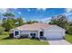 Charming single-story home with a well-manicured lawn, lush landscaping, and an attached two-car garage at 4608 Elwood Rd, Spring Hill, FL 34609