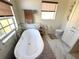 Bright bathroom featuring a soaking tub, marble flooring and walls, and a neutral color scheme at 4748 Yellowstone Dr, New Port Richey, FL 34655
