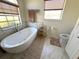 Modern bathroom featuring a standalone soaking tub, marble tile, and contemporary fixtures at 4748 Yellowstone Dr, New Port Richey, FL 34655