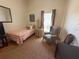 Guest bedroom with a single bed, neutral walls, and a comfortable reading chair at 4748 Yellowstone Dr, New Port Richey, FL 34655