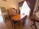 Traditional dining room with wood furniture, decorative wall hangings, and natural light from a large window at 4748 Yellowstone Dr, New Port Richey, FL 34655