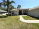 Charming home featuring a well-manicured lawn, curved walkway, and decorative accents around the arched windows at 4748 Yellowstone Dr, New Port Richey, FL 34655