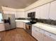 Modern kitchen features white cabinets, granite countertops, stainless steel appliances, and wood flooring at 4748 Yellowstone Dr, New Port Richey, FL 34655