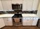 Updated kitchen boasts stainless steel appliances, granite countertops, modern white cabinets, and stylish backsplash at 4748 Yellowstone Dr, New Port Richey, FL 34655