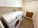 Laundry room featuring new front loading Samsung washer and dryer with white cabinets and wood look floors at 4748 Yellowstone Dr, New Port Richey, FL 34655