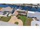 Waterfront home featuring a circular brick driveway, well-manicured lawn, and tropical palm trees under a clear sky at 5033 Cabrilla Ct, New Port Richey, FL 34652
