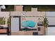 Aerial view of an outdoor pool and patio area with a built-in fire pit, lounge chairs, and manicured greenery at 5033 Cabrilla Ct, New Port Richey, FL 34652