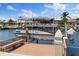 A view of the boat dock featuring a lift and boat on a sunny day at 5033 Cabrilla Ct, New Port Richey, FL 34652