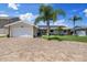 Front exterior features a circular paver driveway, lush landscaping, solar panels, and a three-car garage at 5033 Cabrilla Ct, New Port Richey, FL 34652