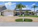 Exterior of a home features well-maintained landscaping, solar panels, and a paver driveway at 5033 Cabrilla Ct, New Port Richey, FL 34652