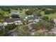 Aerial view of the community clubhouse, lush golf course, and serene lake at 5110 Championship Cup Ln, Spring Hill, FL 34609