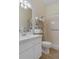Bright bathroom with a white vanity, decorative shelving, and a shower with beige tile at 5110 Championship Cup Ln, Spring Hill, FL 34609