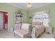 Cozy bedroom featuring a bed, bookshelf, a sitting bench, and a light green wall at 5110 Championship Cup Ln, Spring Hill, FL 34609