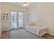 This bedroom is flooded with natural light from French doors with a ceiling fan, and a day bed at 5110 Championship Cup Ln, Spring Hill, FL 34609