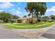 Lovely view of a home with a well-kept lawn, mature trees, and a quiet residential street at 5110 Championship Cup Ln, Spring Hill, FL 34609
